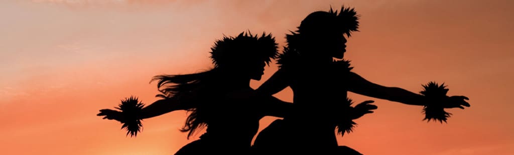 Two hula dancers at sunset