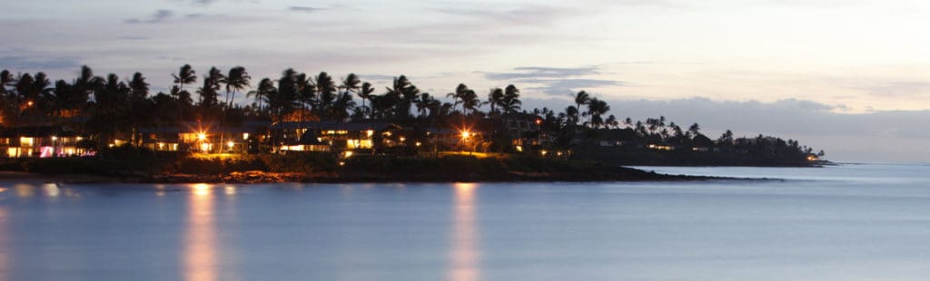 Where to stay on Maui: evening on Napili Bay with lights on at condos